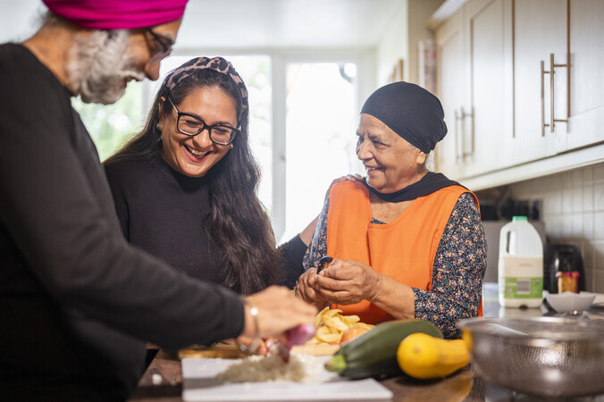 People preparing veg and smiling