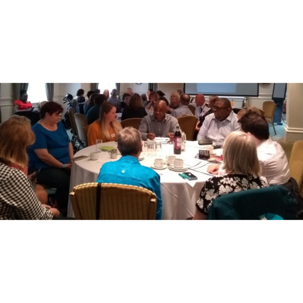 Photo of people sat around table at event