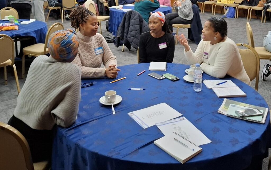 Photograph of people sat around table chatting