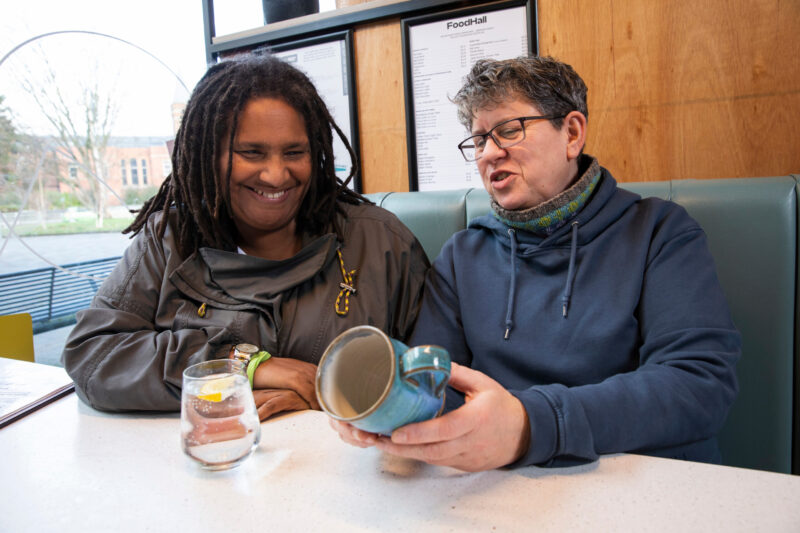 Two women looking at a mug