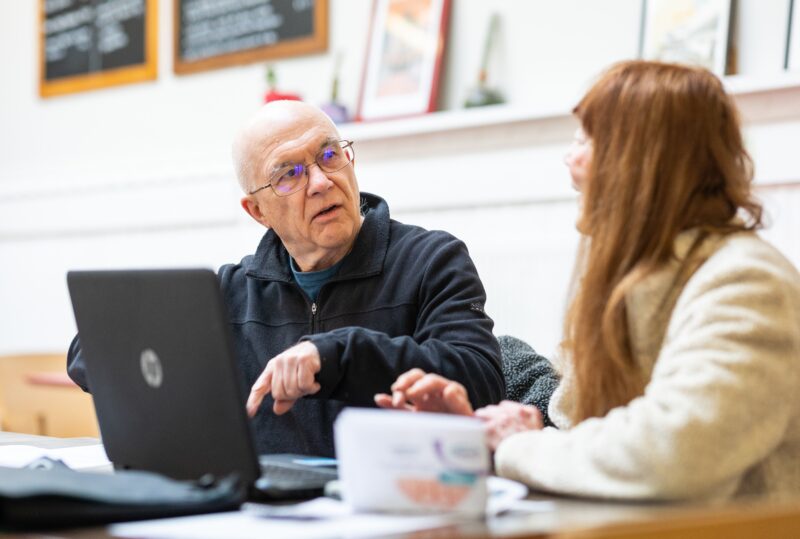 Man on laptop with woman sat next to him