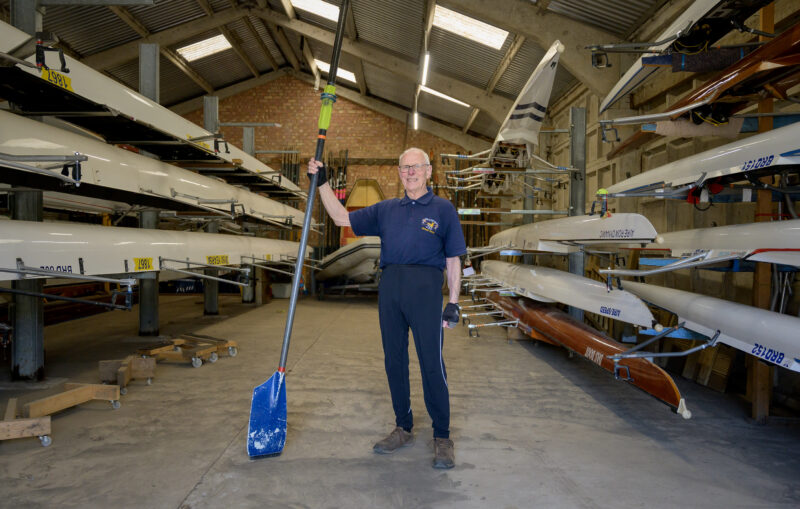 Man with oar in boat shed