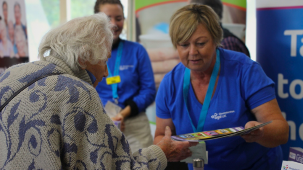 Image of lady who works at Age UK handing out flyers