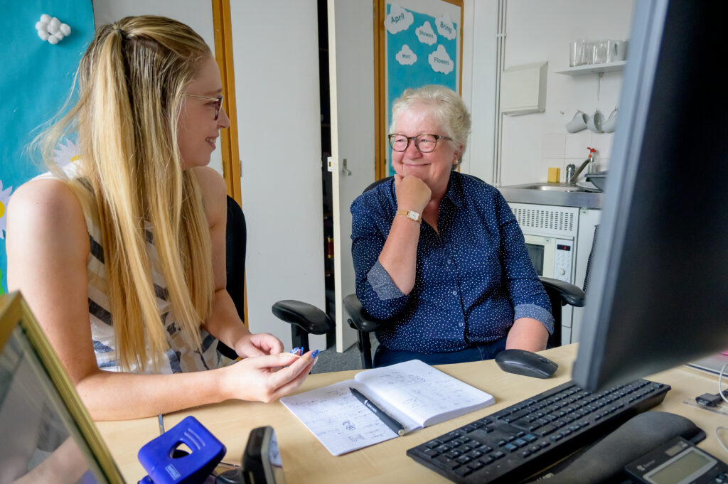 Photo of two women sat at desk