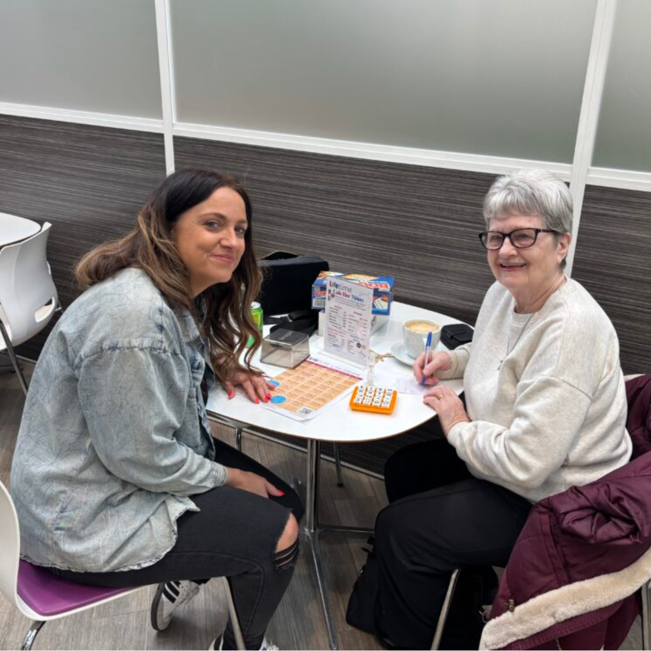  Photo of woman sat in cafe playing a game