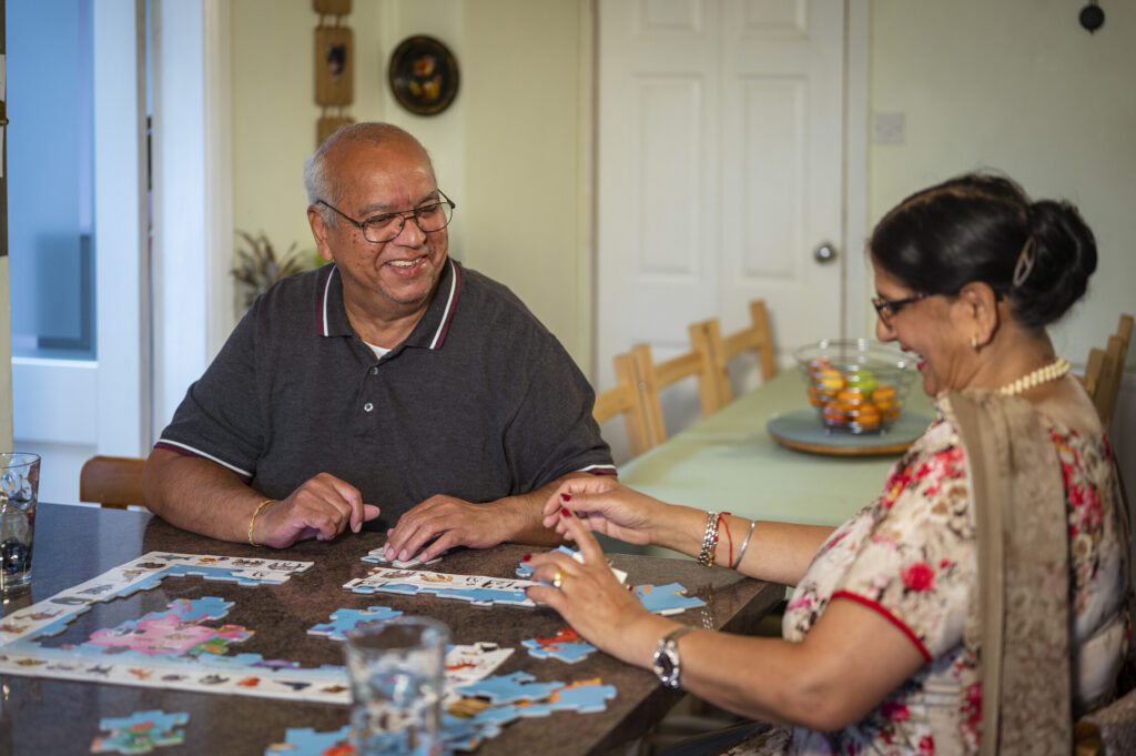 Two people at a table doing a jigsaw