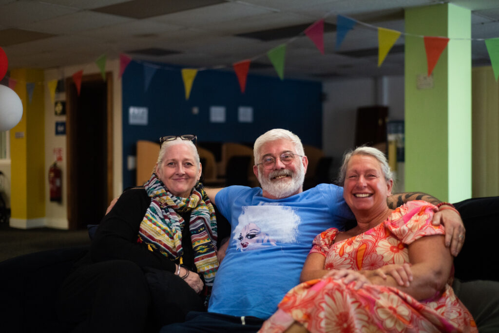 Man sat with arms around two women