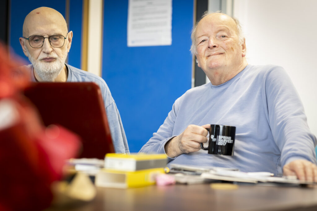 Picture of two men sat at laptop