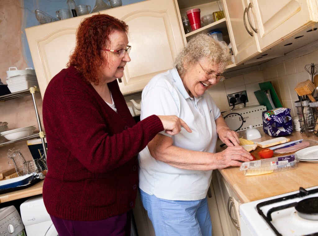 Two women preparing food in a kitchen