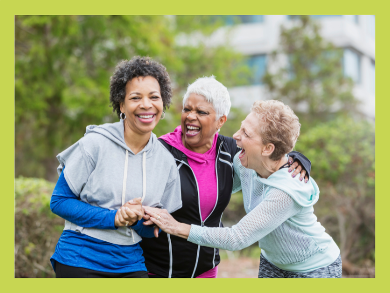 Three women laughing in a park