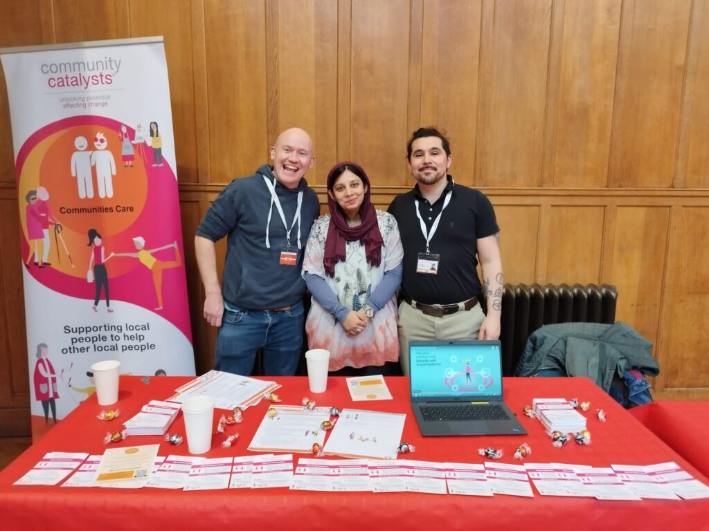 Three people standing at an exhibition stand.