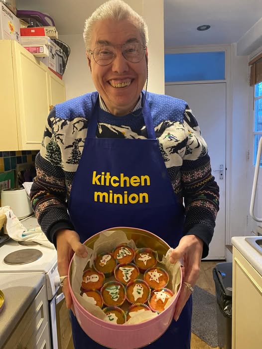 A man holding a tray of cakes