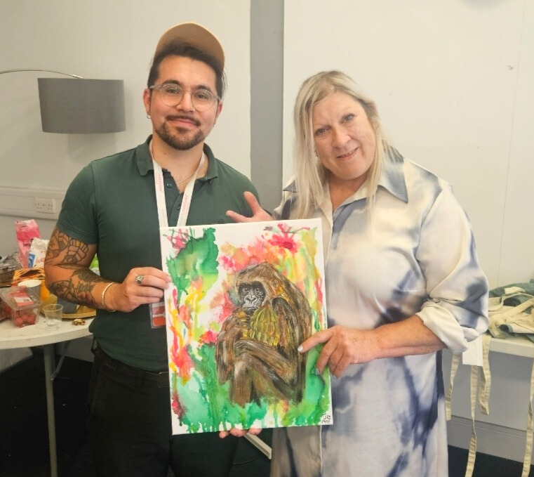 Two people holding a painting