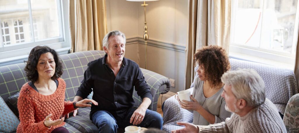Four people chatting in a living room