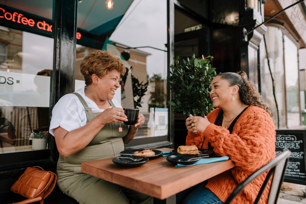 Two women sitting having coffee outside a cafe