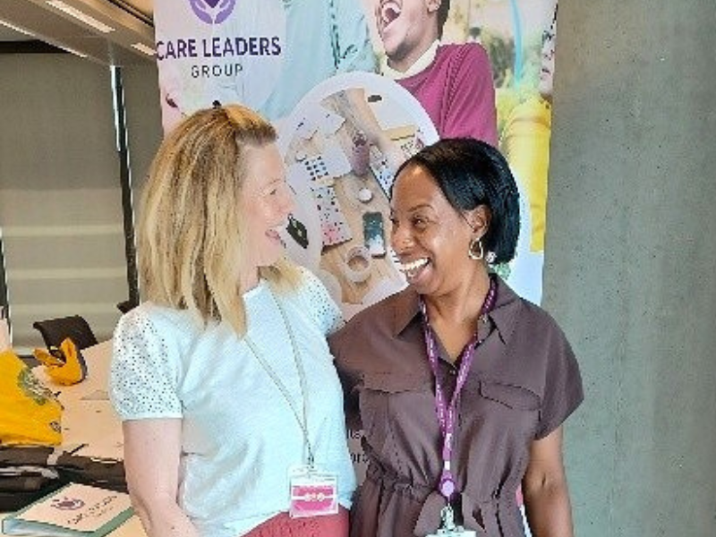 Two women chatting at an event stand