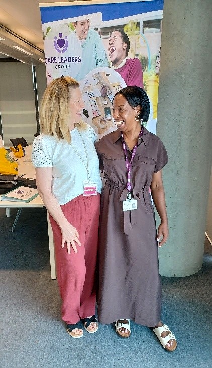Two women chatting at an event stand