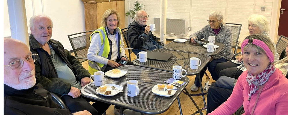 A group of people sitting around a table in a community centre